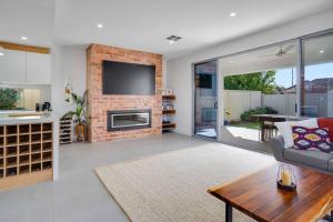 a living room with a couch and a fireplace at Modern 3 BR home in Fulham in Henley Beach South