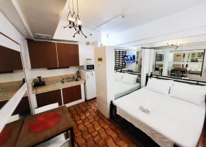 ein kleines Zimmer mit 2 Betten und einer Küche in der Unterkunft Bright Makati Glass View By GreenBelt in Manila