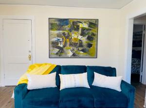 a blue couch in a living room with a painting at Great Location, Roomy, Modern, Private Office, and Pet Friendly in Evanston