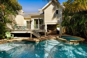 una piscina frente a una casa en Time for the Sea - Holmes Beach, FL, en Holmes Beach