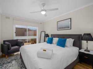 a bedroom with a large bed and a chair at Nook on Nixon in Shepparton