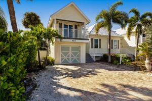 una casa con palmeras delante en Time for the Sea - Holmes Beach, FL, en Holmes Beach