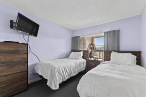 a bedroom with two beds and a flat screen tv at Stowe Ski Chalet - 3BR with In Unit Sauna in Stowe +27 photos