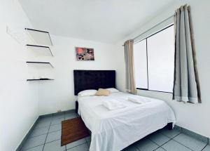 a bedroom with a bed and a large window at Bravo Surf Camp in Punta Hermosa