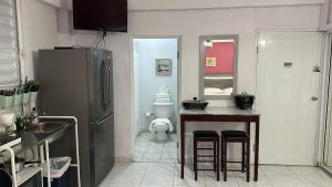 a kitchen with a refrigerator and a table and a toilet at Playa Apartments in Salinas