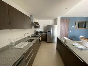 a kitchen with a sink and a refrigerator at Departamento 1 habitación - Latitud La Victoria a 5 minutos del centro in Querétaro