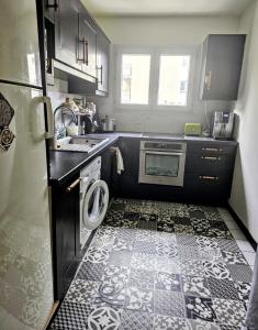 una pequeña cocina con lavadora y secadora. en Appartement spacieux silencieux, en Lognes
