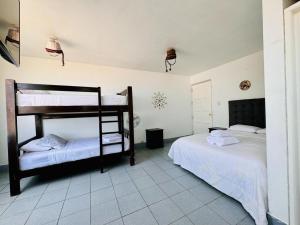 a bedroom with two bunk beds in a room at Bravo Surf Camp in Punta Hermosa