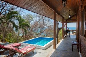 una piscina en un patio con sillas y una casa en Casa Amico Beach House, en El Gigante
