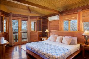 ein Schlafzimmer mit einem Bett in einem Zimmer mit Fenstern in der Unterkunft Casa Amico Beach House in El Gigante