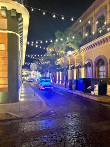 un coche aparcado en una calle de la ciudad por la noche en Casa Carlota Mazatlán en Mazatlán