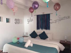 Zimmer mit einem Bett mit Ballons an der Wand in der Unterkunft Celeste Villa de Leyva in Villa de Leyva