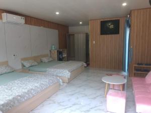 Habitación de hotel con 2 camas y mesa en The Sunrise Anh Tu, en Cam Ranh