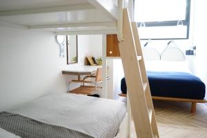 een kleine slaapkamer met een stapelbed en een bureau bij NiHao Café Hotel in Taipei