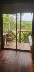 una porta aperta su una veranda in legno con panchina di Cabaña Palo Verde a Puntarenas