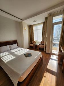 a bedroom with a large bed and a large window at Golden Sea Hotel in Nha Trang