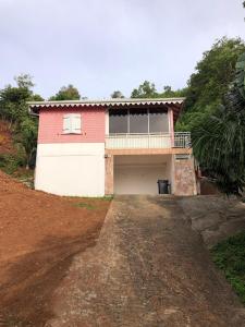 una casa roja y blanca con garaje en Villa pour 4 à 8 personnes près des plages du Sud & Marina du Marin - Wi-Fi sur demande, en Le Marin