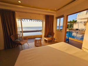 - une chambre avec un lit et une vue sur l'océan dans l'établissement Blue Coast Beach Hotel, à Santa Ana