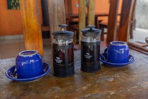 three containers sitting on a table with blue saucers at La village hills view in Nusa Penida