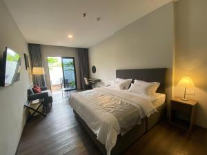 una camera con un grande letto e un balcone di ONYX HOTEL & VILLA a Tanjunguban
