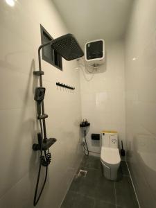 La petite salle de bains est pourvue d'une douche et de toilettes. dans l'établissement Homestay 1999, à Tân Tạo