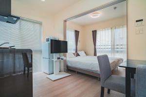 1 dormitorio con cama, mesa y TV en Hotel Star Residence - 無人ホテル en Fukuoka