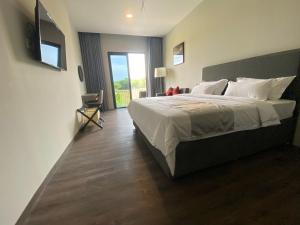 ein Schlafzimmer mit einem großen Bett und einem Fenster in der Unterkunft ONYX HOTEL & VILLA in Tanjunguban