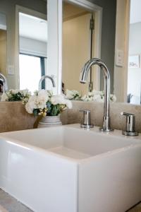 a white sink with two faucets and a mirror at 4) Hermoso departamento cómodo y equipado! in Godoy Cruz