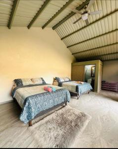 a bedroom with two beds and a ceiling at Tinyhouses and Tropical Gardens in Zambrano