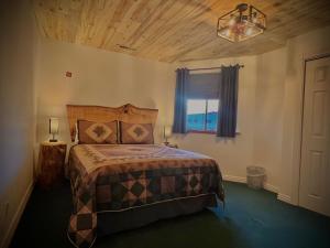 a bedroom with a bed and a window at THE SNUGGLE INN in Loa