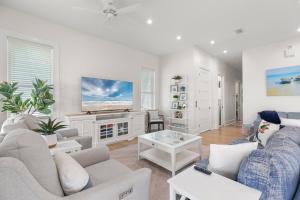 een woonkamer met witte meubels en een flatscreen-tv bij Kiskadee - Private beachhouse wih pool home in South Padre Island
