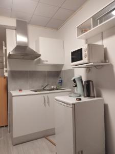 cocina con armarios blancos y microondas en Modern Lux studio, en Beringen