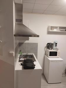 cocina blanca con fogones y microondas en Modern Lux studio, en Beringen