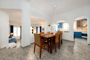 uma sala de jantar e cozinha com mesa e cadeiras em ALYKI'S FAMILY POOL Villa em Aliki