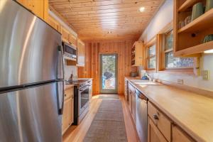 una cocina con nevera de acero inoxidable y armarios de madera en Spacious, Central, & Cozy Cabin Near Lake & Trails en Carnelian Bay