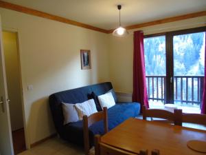 a living room with a blue couch and a table at Appartement Valfréjus, 3 pièces, 8 personnes - FR-1-561-112 in Modane