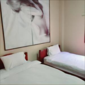 2 camas en una habitación con una foto en la pared en Queens Backpackers Hostel, en Vang Vieng