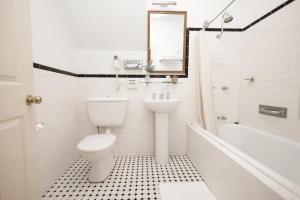 a white bathroom with a toilet and a sink at Leura House in Leura