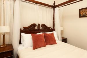 1 dormitorio con 1 cama con sábanas blancas y almohadas rojas en Leura House en Leura