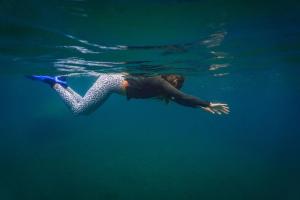 a woman is swimming in the water at Dolphin Quest Jungle Lodge in Piedras Blancas