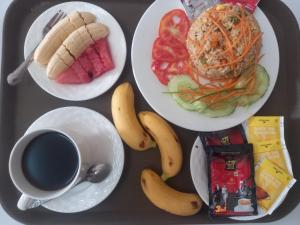 bandeja con platos de comida y una taza de café en Queens Backpackers Hostel, en Vang Vieng