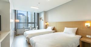 2 camas en una habitación de hotel con ventana en Dahlbit stay en Incheon