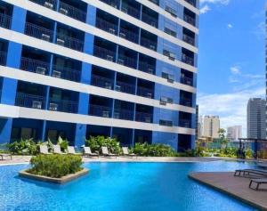 a swimming pool in front of a building at Kensal Industrial - Air Residences in Manila