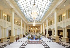 a large lobby with a glass ceiling and columns at Hotel Amsterdam Huis Ten Bosch in Sasebo