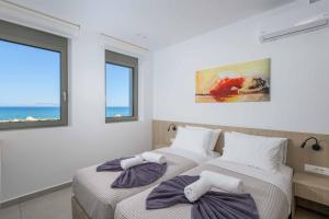 Dos camas en una habitación con dos ventanas. en Villa Panaxia Akte, en Theologos 18 fotos más