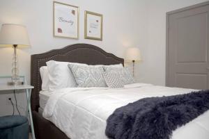 um quarto com uma cama branca e um cobertor roxo em Belle Suite -8mins from Disney, Centrally Located! em Anaheim