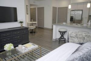 uma sala de estar com um sofá e uma cozinha em Belle Suite -8mins from Disney, Centrally Located! em Anaheim