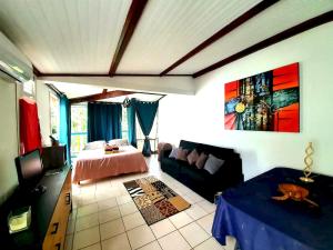 a living room with a bed and a couch at Studio agréable à Sainte-Anne de 30 m² avec piscine partagée in Sainte-Anne