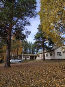 un coche aparcado frente a un edificio con árboles en Lapland Old School en Muonio