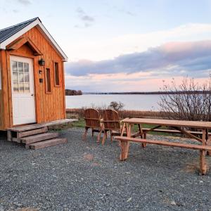 a picnic table and chairs in front of a cabin at Waterfront Tiny House near Pomquet Beach in Antigonish